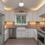 white wooden kitchen cabinet with white pendant lamp