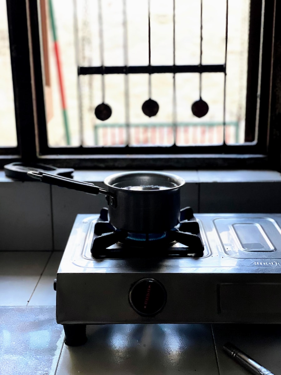 a stove top sitting on top of a counter next to a window